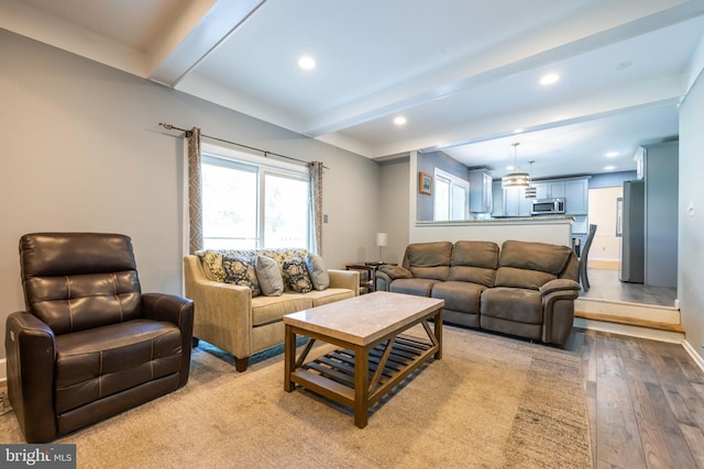 living room with baseboards, light wood-style flooring, recessed lighting, and beam ceiling