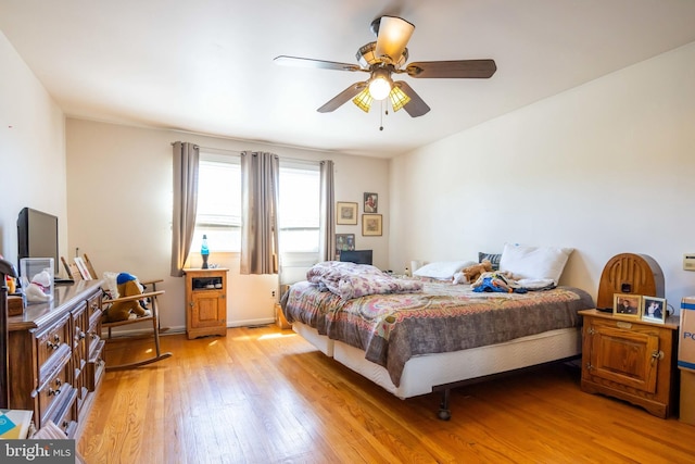 bedroom with baseboards, ceiling fan, and light wood-type flooring