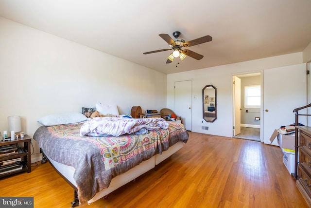 bedroom featuring baseboards, ceiling fan, wood finished floors, and visible vents