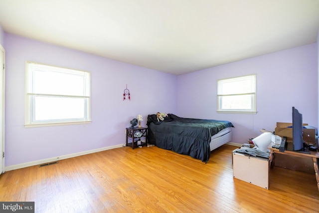 bedroom featuring visible vents, baseboards, and light wood-type flooring