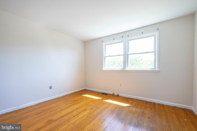 unfurnished room with baseboards, visible vents, and light wood-style flooring
