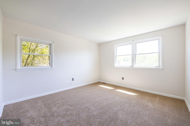 carpeted empty room with baseboards