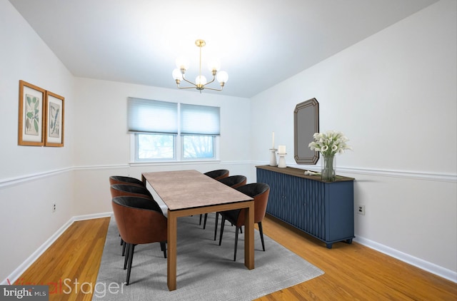 dining area with an inviting chandelier, baseboards, and wood finished floors