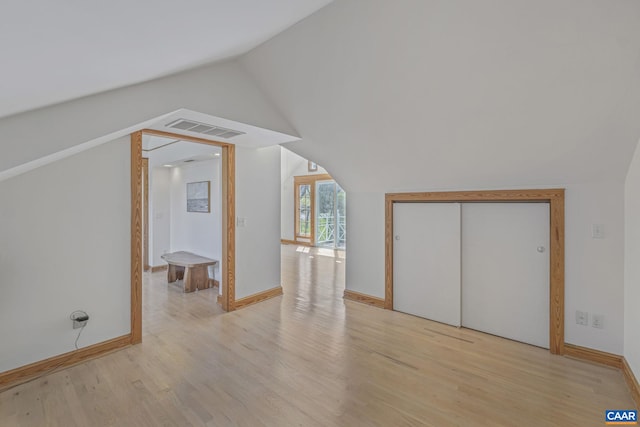 bonus room with light wood finished floors, lofted ceiling, and baseboards