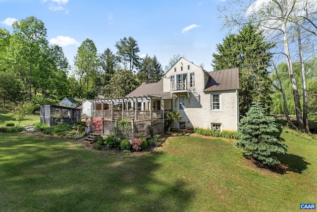 back of property with a standing seam roof, a wooden deck, a lawn, metal roof, and a pergola