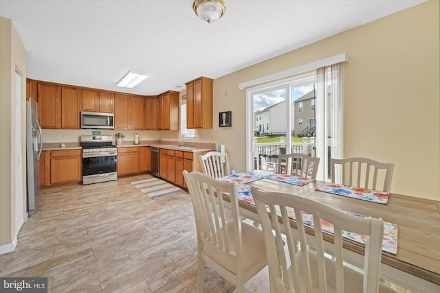 11 Gooseneck Ln, Smyrna, DE 19977 - kitchen with stainless steel appliances, a sink, light countertops, and brown cabinets