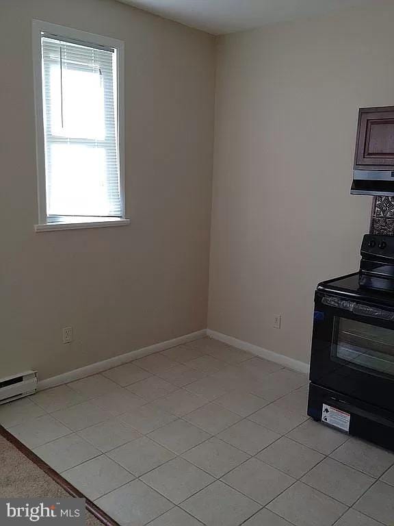 unfurnished dining area featuring baseboards and light tile patterned floors