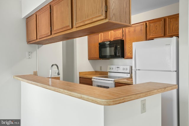 kitchen with brown cabinetry, a peninsula, white appliances, light countertops, and a sink
