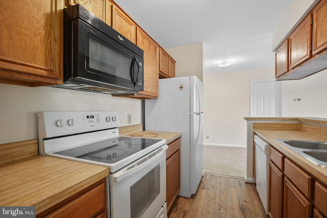 kitchen featuring light countertops, brown cabinets, and white appliances