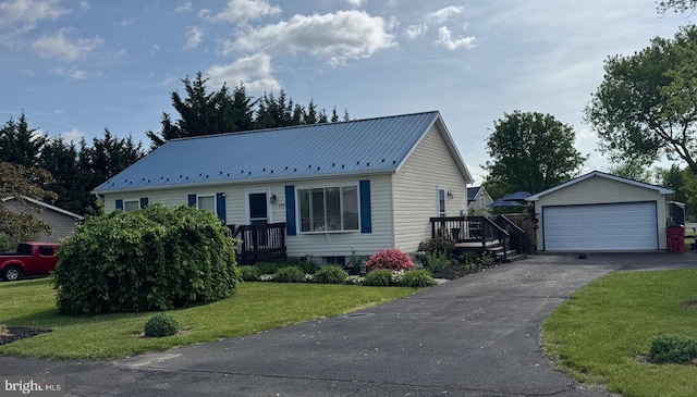 single story home featuring metal roof, a front yard, and a garage