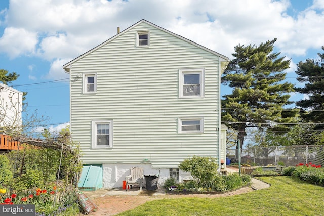 rear view of property with fence and a yard