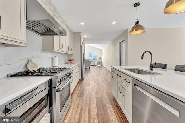 20 Wolfpack Rd, Hamilton, NJ 08619 - kitchen with decorative light fixtures, range hood, a sink, light wood-style floors, and stainless steel appliances