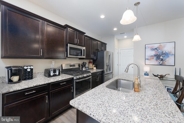 50 Wexford Ct, Morgantown, PA 19543 - kitchen featuring a kitchen island with sink, light stone countertops, a sink, stainless steel appliances, and visible vents