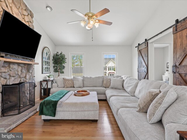 214 Primavera Cir, Sterling, VA 20165 - living area with a ceiling fan, a fireplace, wood finished floors, a barn door, and lofted ceiling