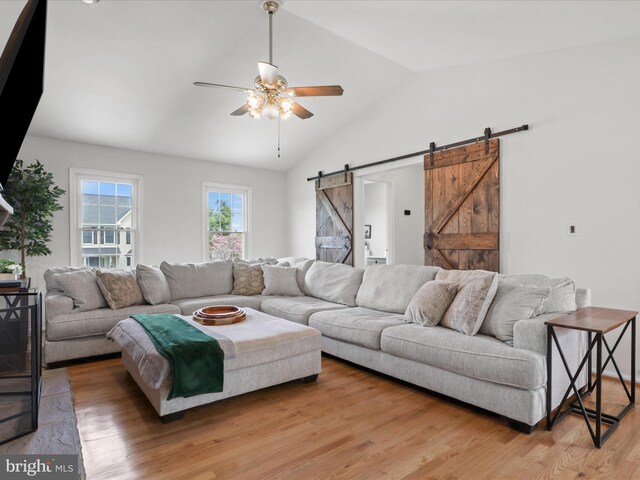 214 Primavera Cir, Sterling, VA 20165 - living room with ceiling fan, vaulted ceiling, a barn door, and light wood finished floors