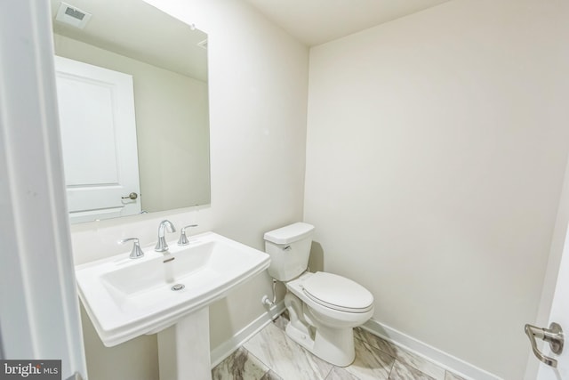 bathroom featuring visible vents, marble finish floor, toilet, baseboards, and a sink