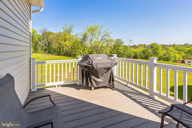 wooden terrace with a yard and grilling area