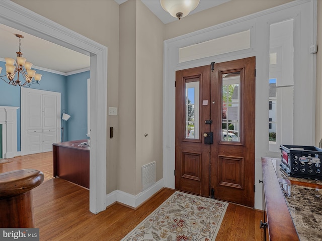 203 S George St, Charles Town, WV 25414 - entryway featuring a notable chandelier, visible vents, baseboards, ornamental molding, and wood finished floors