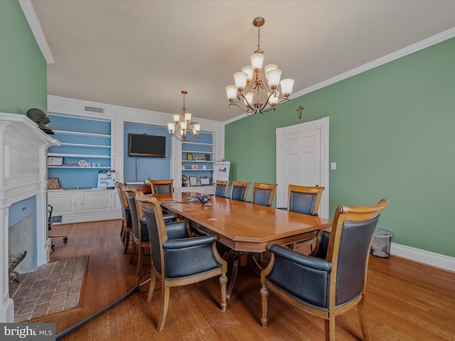 203 S George St, Charles Town, WV 25414 - dining area featuring a fireplace, wood finished floors, a chandelier, and crown molding