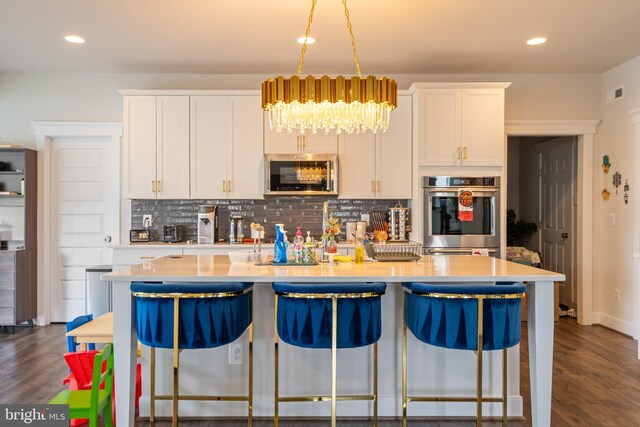 35898 Quantum Pl, Round Hill, VA 20141 - kitchen with stainless steel appliances, a center island with sink, tasteful backsplash, light countertops, and recessed lighting