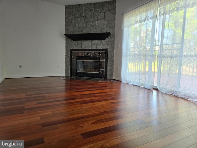 unfurnished living room featuring a fireplace and wood finished floors
