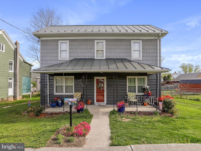 view of front of house with a front lawn, fence, a standing seam roof, metal roof, and a porch