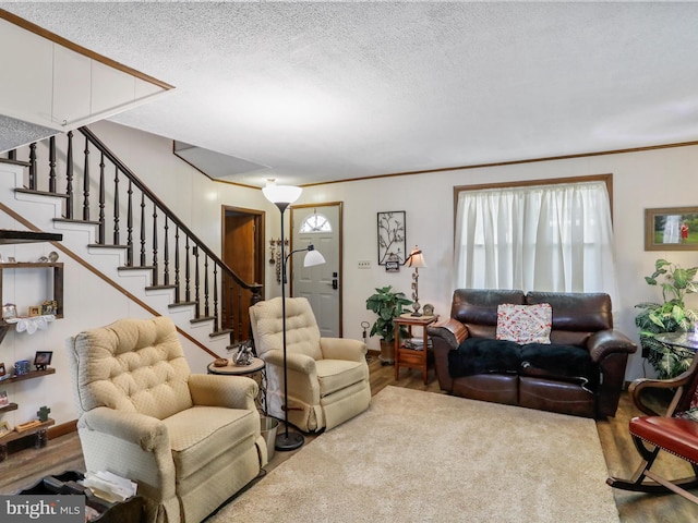living area featuring crown molding, stairs, wood finished floors, and a wealth of natural light