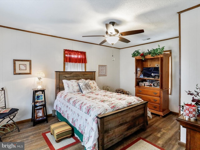 bedroom featuring crown molding, dark wood-style flooring, ceiling fan, and visible vents