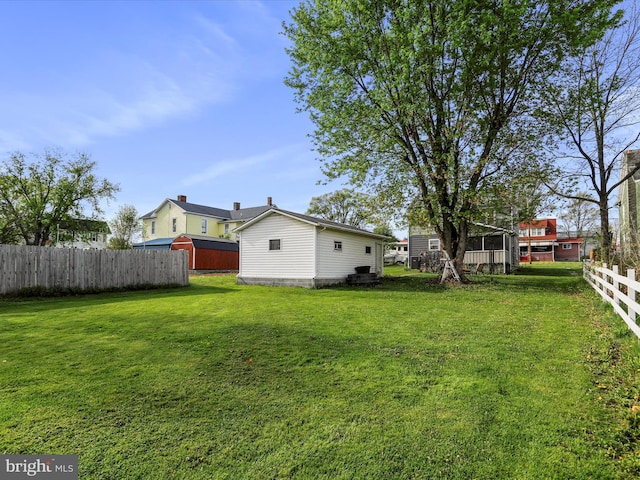 view of yard featuring fence and an outbuilding