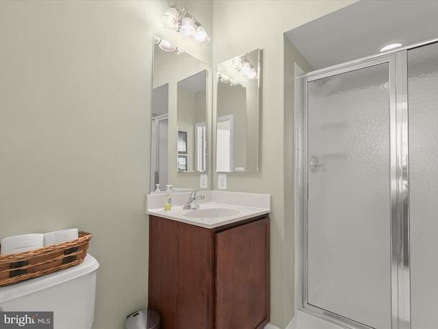 bathroom with vanity, a stall shower, and toilet