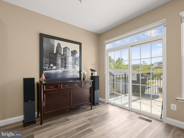 doorway featuring baseboards, visible vents, and light wood-style floors