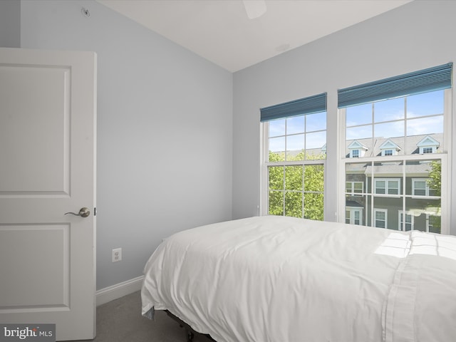 carpeted bedroom featuring a ceiling fan, baseboards, and lofted ceiling