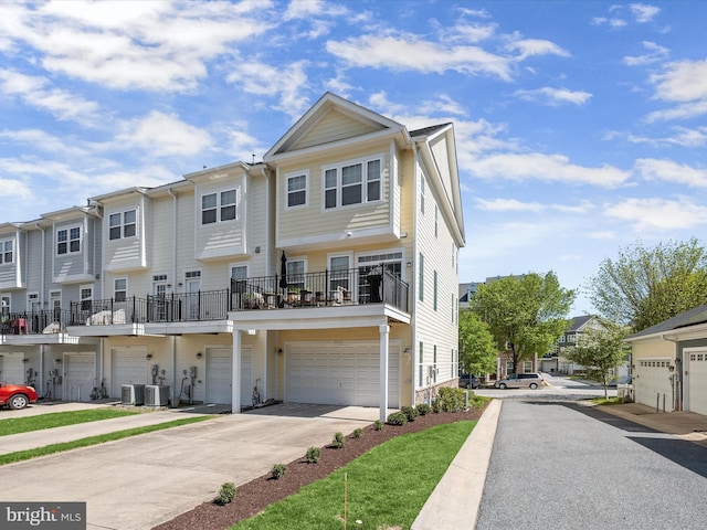 townhome / multi-family property featuring a garage, central AC, a residential view, and concrete driveway