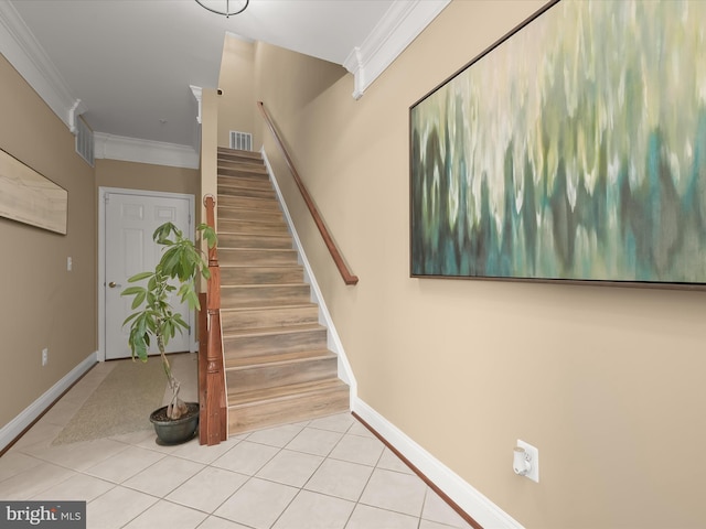 stairs with tile patterned floors, ornamental molding, baseboards, and visible vents