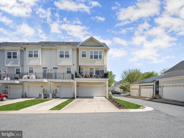 view of property with central AC, driveway, and a garage