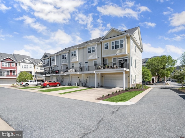 townhome / multi-family property featuring a residential view, an attached garage, and driveway