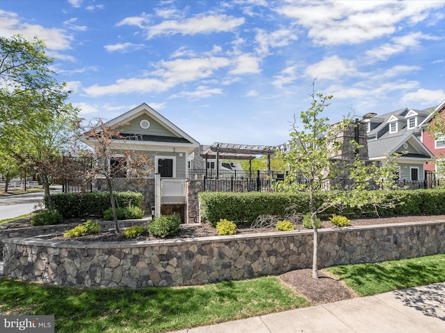view of home's community with fence and a pergola