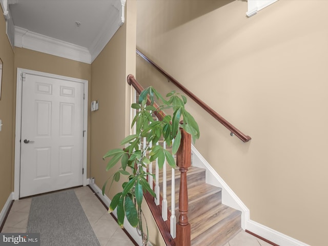 interior space featuring crown molding, baseboards, and stairs