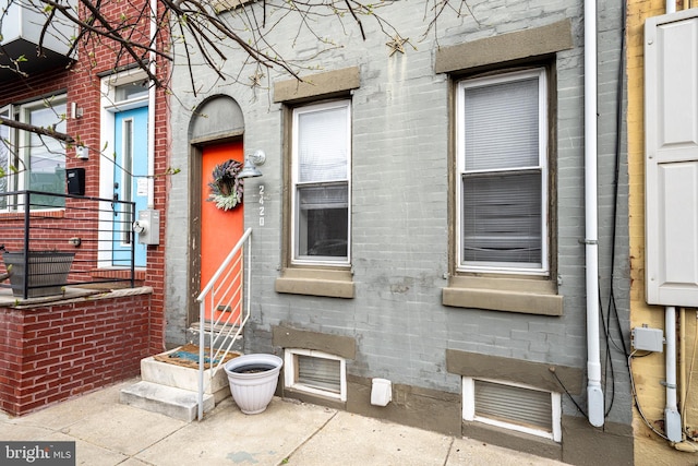 view of side of home featuring entry steps and brick siding