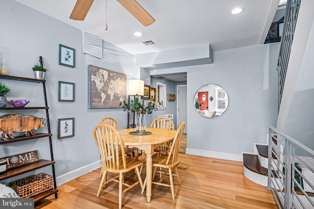 dining room featuring visible vents, ceiling fan, light wood-style floors, and baseboards