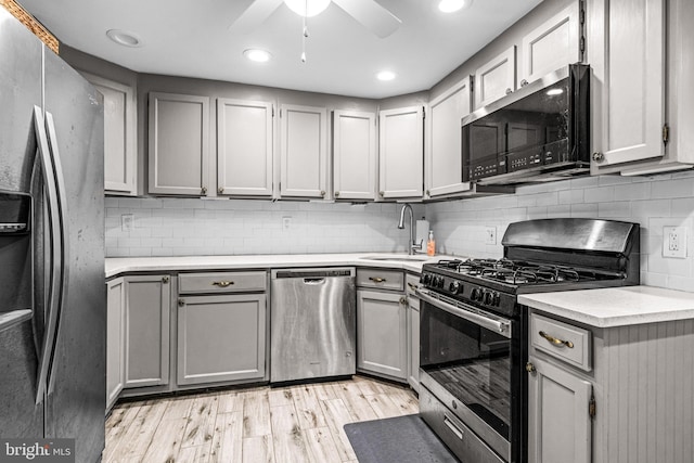 kitchen featuring gray cabinetry, a sink, and appliances with stainless steel finishes
