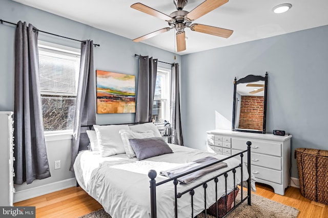 bedroom with ceiling fan, light wood-type flooring, and baseboards