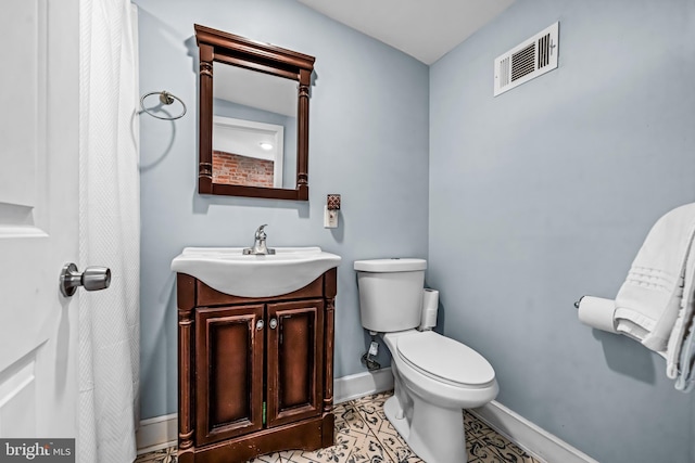bathroom featuring toilet, visible vents, vanity, and baseboards