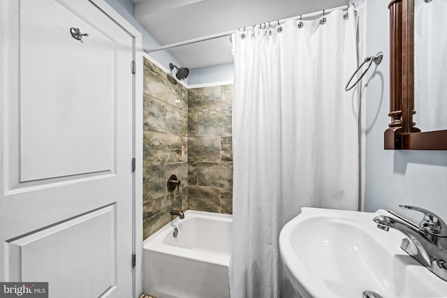 full bathroom with shower / bath combo with shower curtain and a sink
