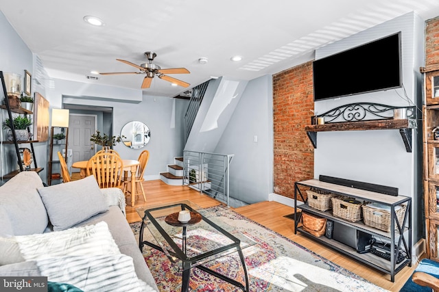 living room with recessed lighting, wood finished floors, brick wall, baseboards, and a ceiling fan