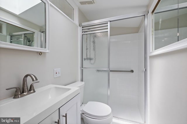 full bathroom featuring toilet, tiled shower, and vanity