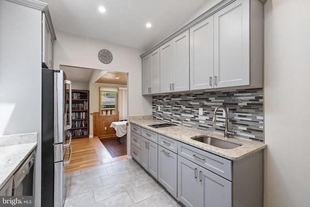 kitchen with a sink, appliances with stainless steel finishes, gray cabinetry, decorative backsplash, and recessed lighting