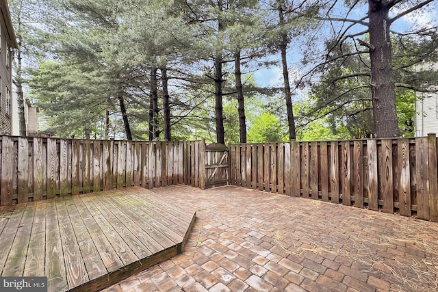 view of patio / terrace featuring a gate, a fenced backyard, and a deck