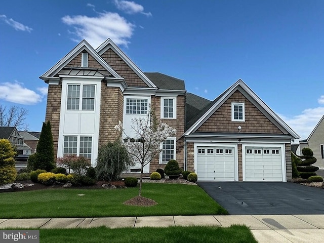 view of front of home with a garage, driveway, and a front yard