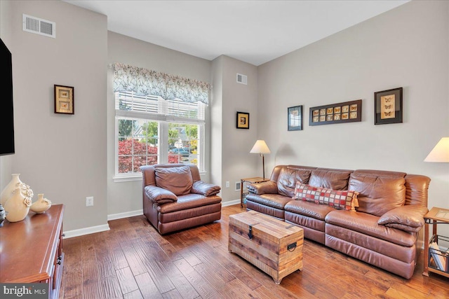 living room featuring baseboards, wood finished floors, and visible vents